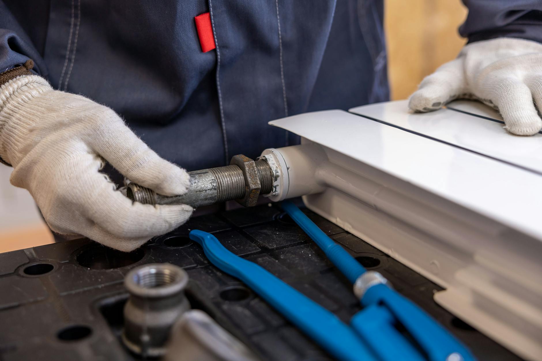 professional plumber installing a radiator pipe